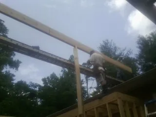 Carpenter setting a ridge beam over a new addition frame — Ice Dam Removal by Roofing Brothers in Rockhill Furnace