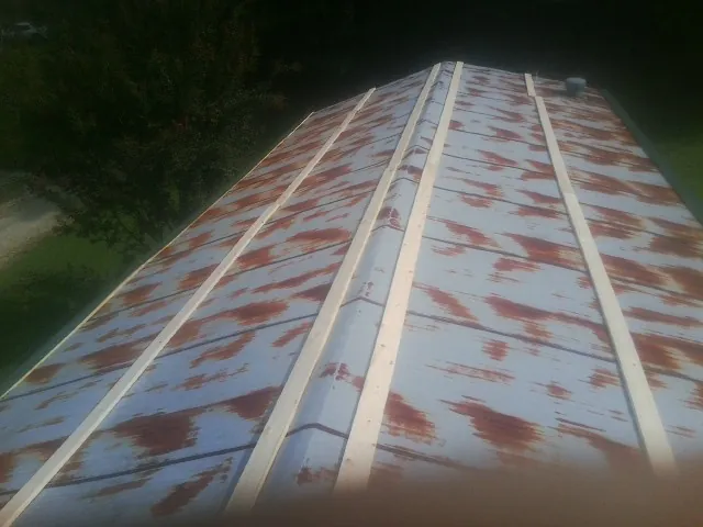 Rusted metal roof panels with new wood purlins before replacement — Storm Damage Roof Repair in Rockhill Furnace by Roofing Brothers