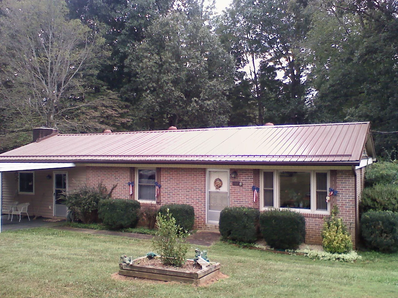 Bronze metal roof on a brick ranch home with a carport in Rockhill Furnace