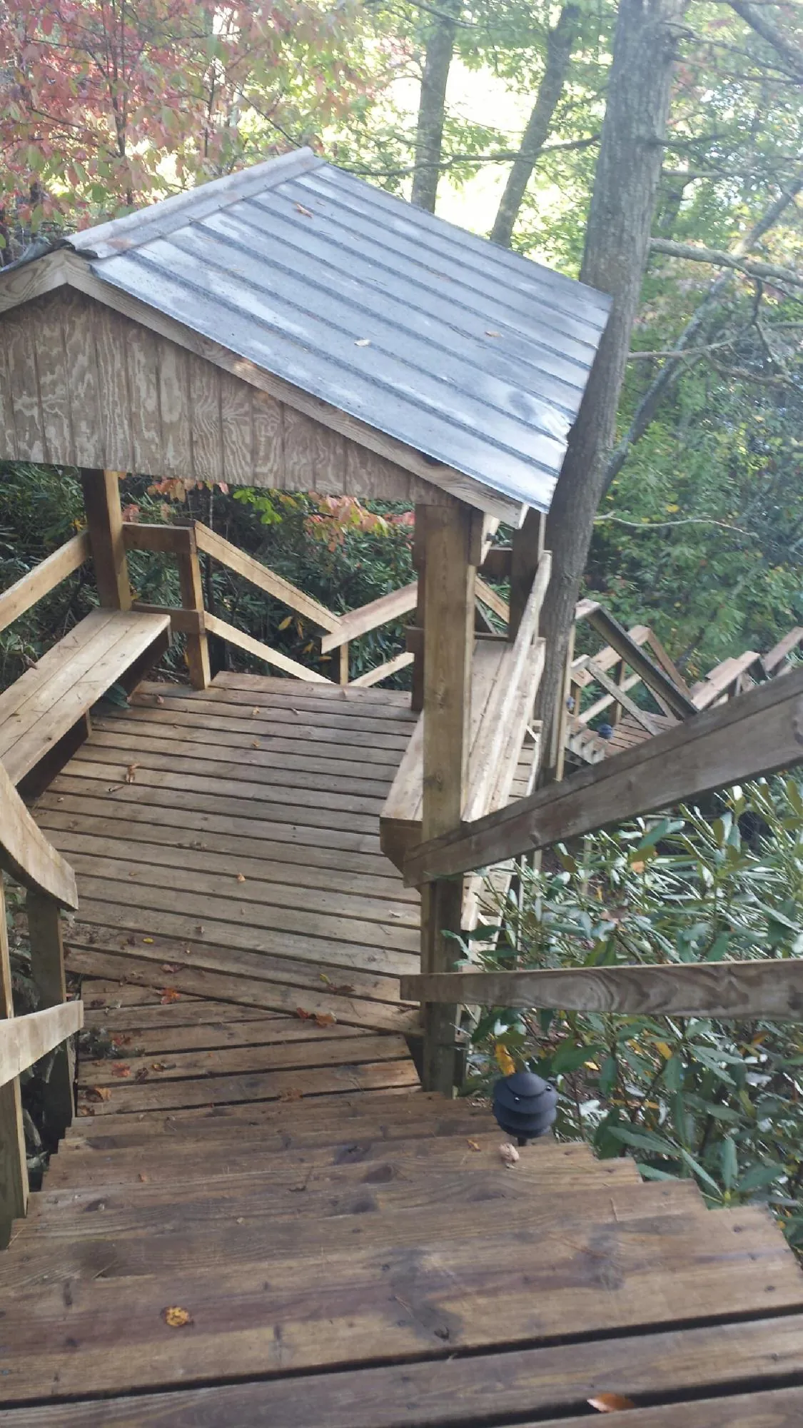 Metal roofed shelter over wooden steps on a wooded walkway — Skylight Repair & Installation work by our crew in Rockhill Furnace
